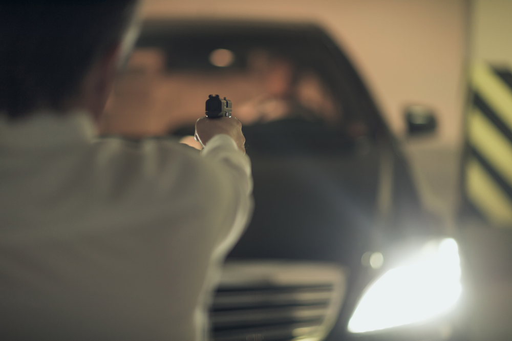 rear-view-of-men-with-handgun-aiming-the-car-driver