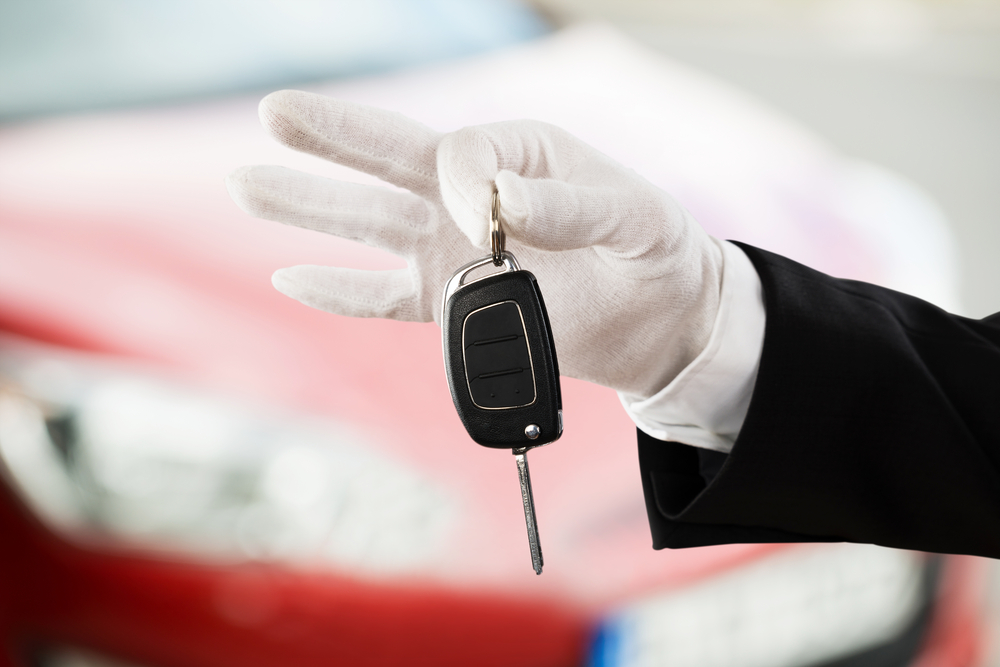 Close-up Of A Valet Boy Hand Holding Car Key Outside The Car