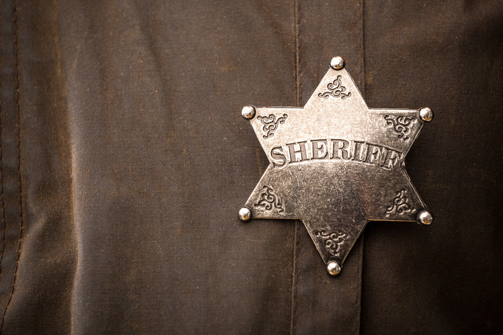 Close up of sheriff badge when on his coat duster