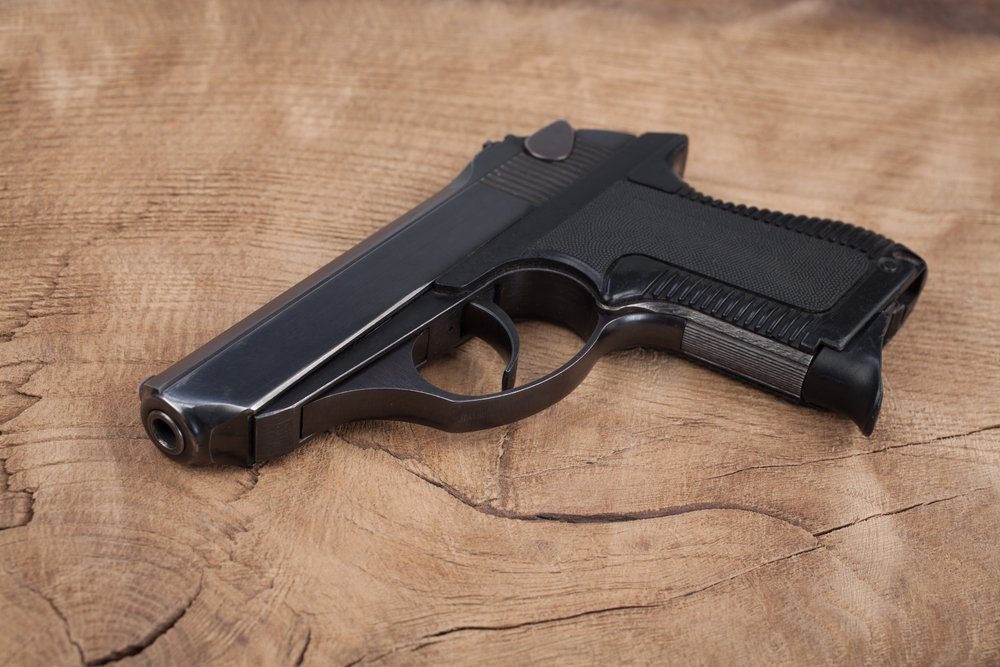 handgun with ammunition on the wooden table