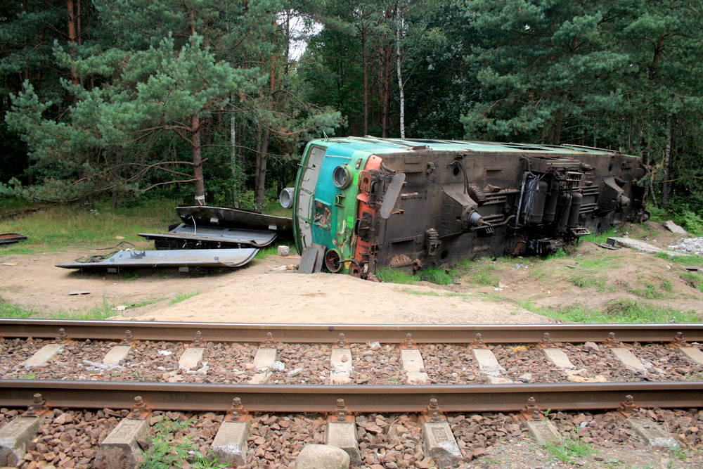 Fatal train crash. Derailed locomotive laying in the woods