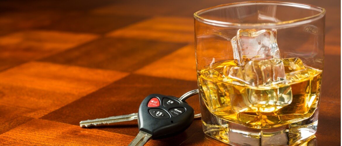 A whiskey on the rocks next to a set of keys