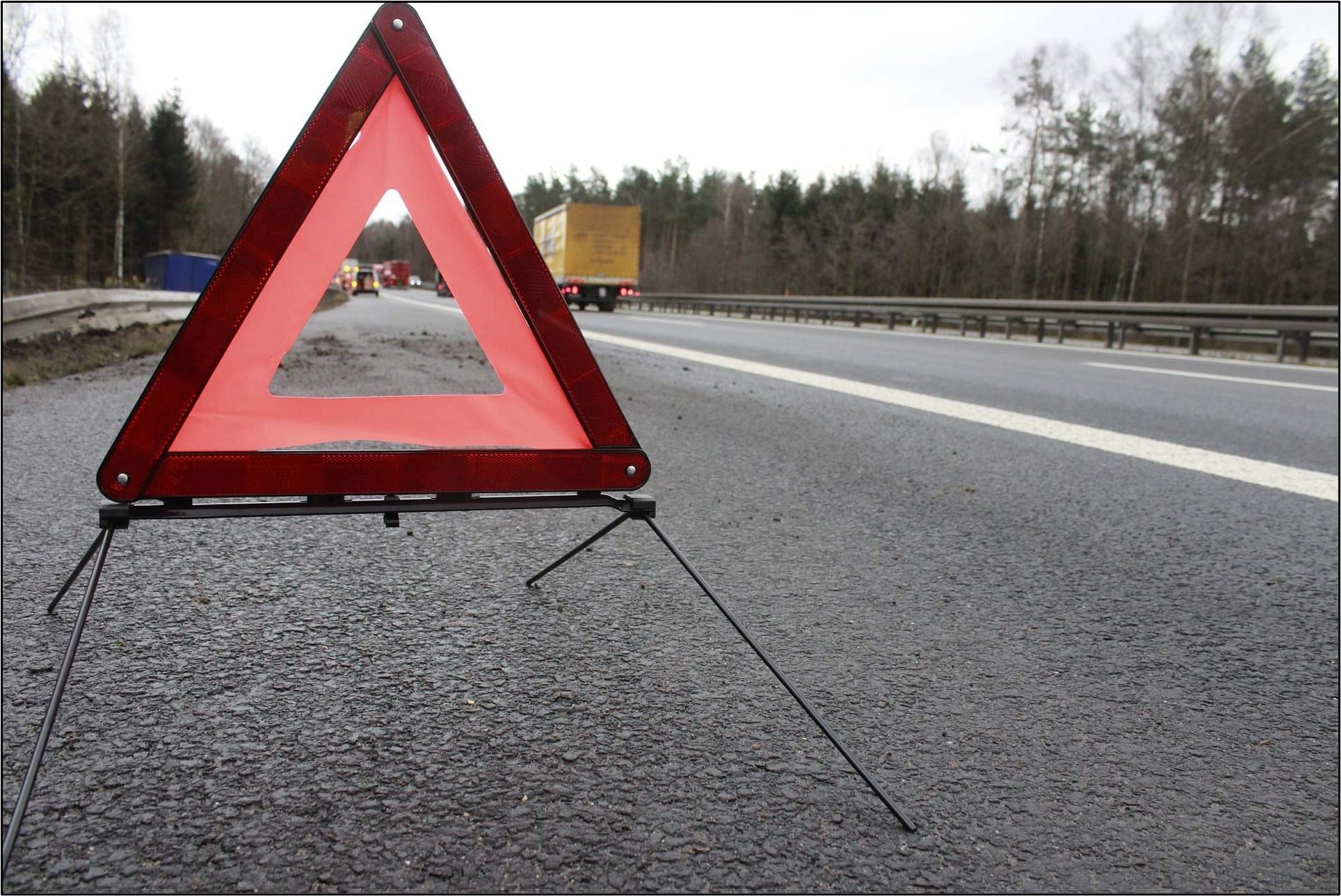 Red warning triangles on side of road