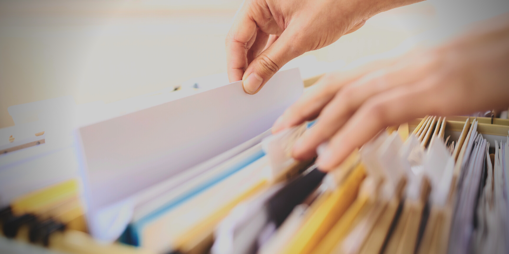 Someone rummaging through files in a filing cabinet