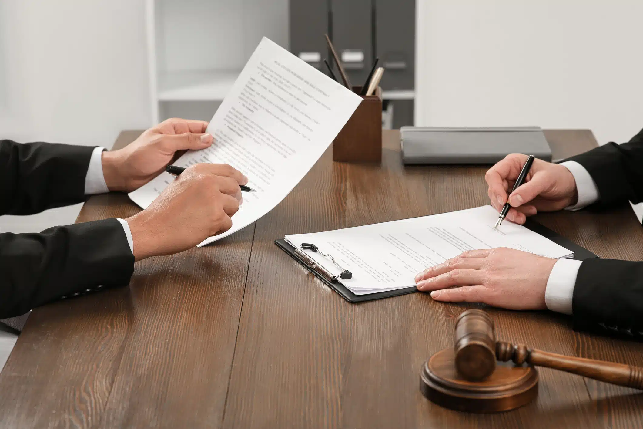 2 people signing documents at a desk